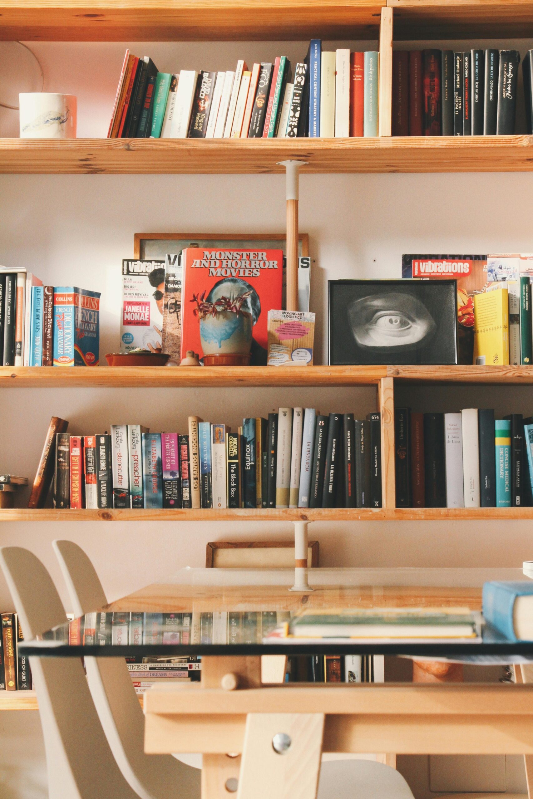 A modern interior featuring wooden bookshelves filled with various books in a cozy reading space.